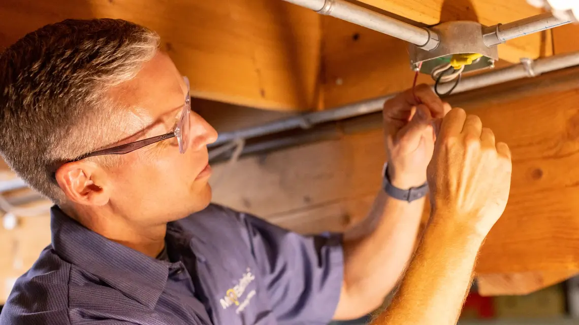 electrician installing a ceiling fan