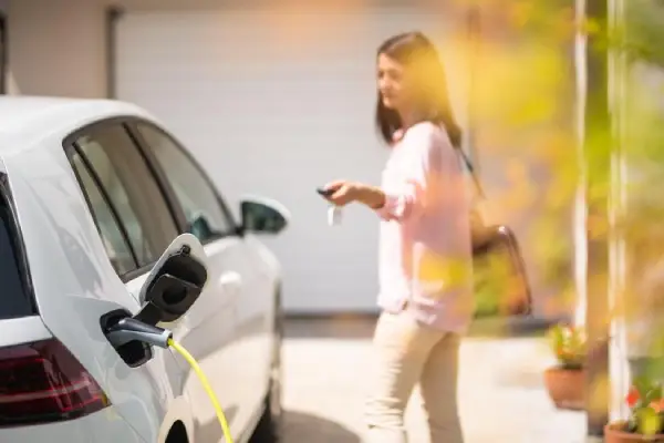 Women charging electric car.