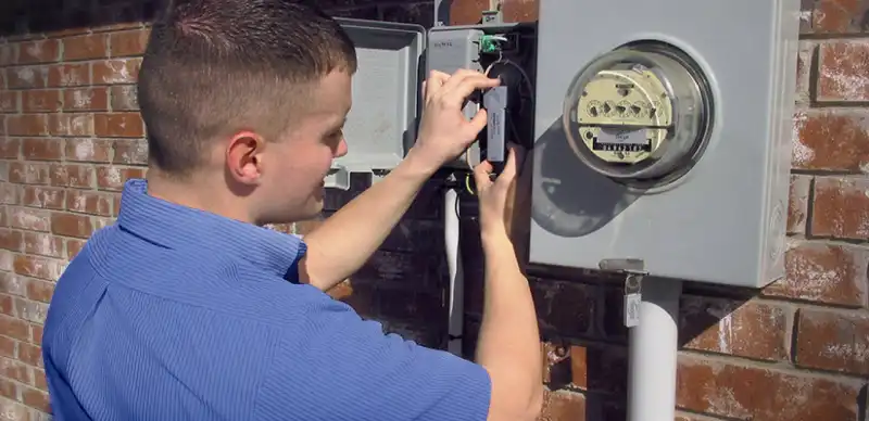 Electrician installing surge protector device to outdoor electrical panel.